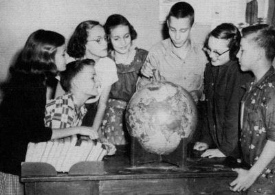 Six students looking at round globe.
